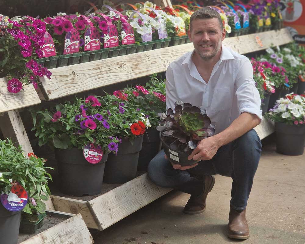 Anthony Gould, owner of Goulds, standing infront of a vibrant display of flowers