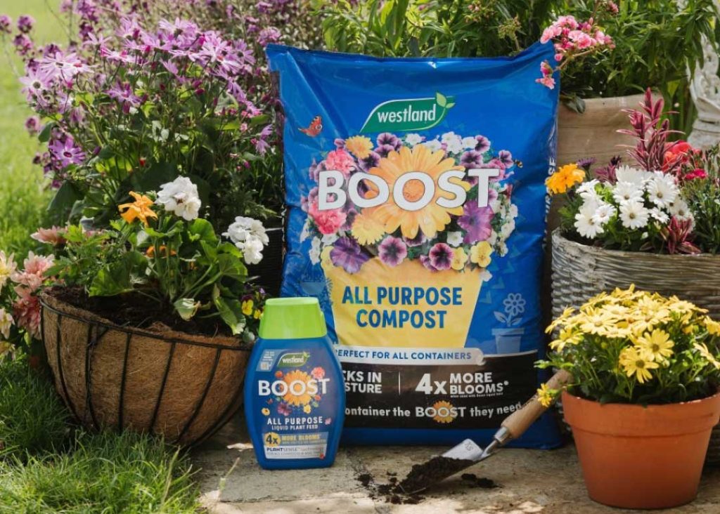 Westland Boost All Purpose Compost - 46L bag, surrounded by flowers and potted pants