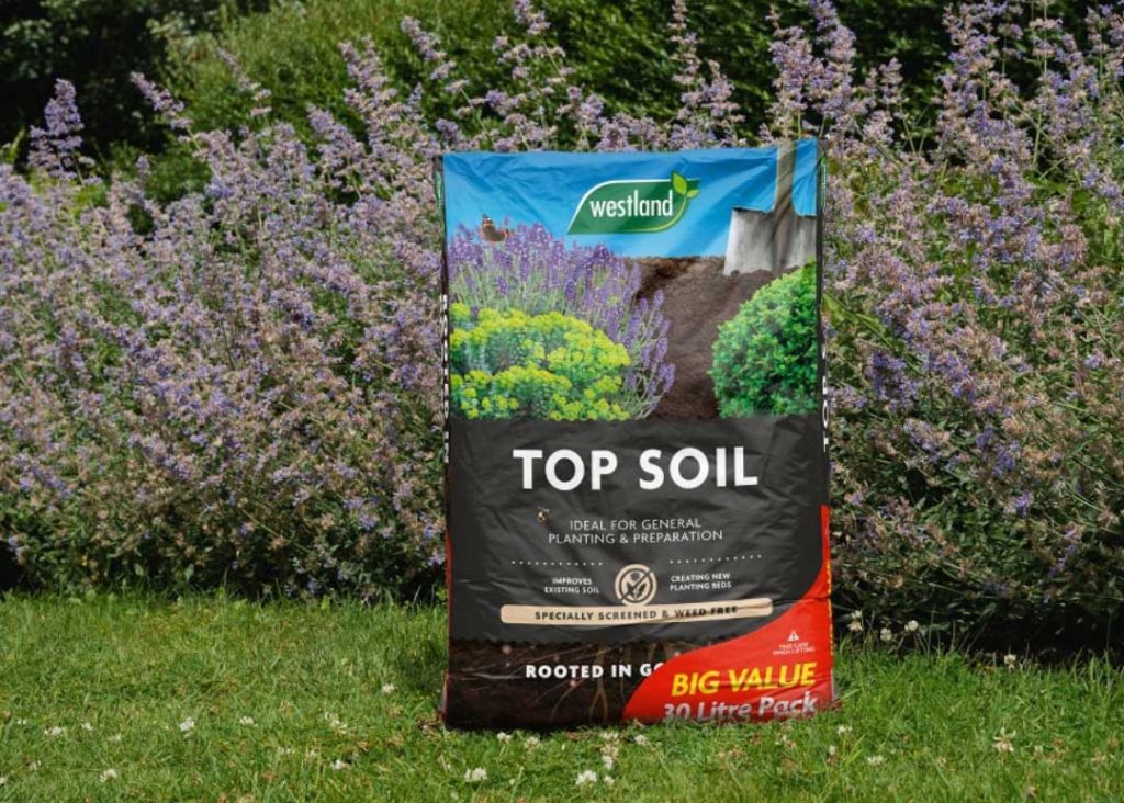 Bag of Westlands Top-Soil BIG value 30L, on a grass lawn in front of lavender plants